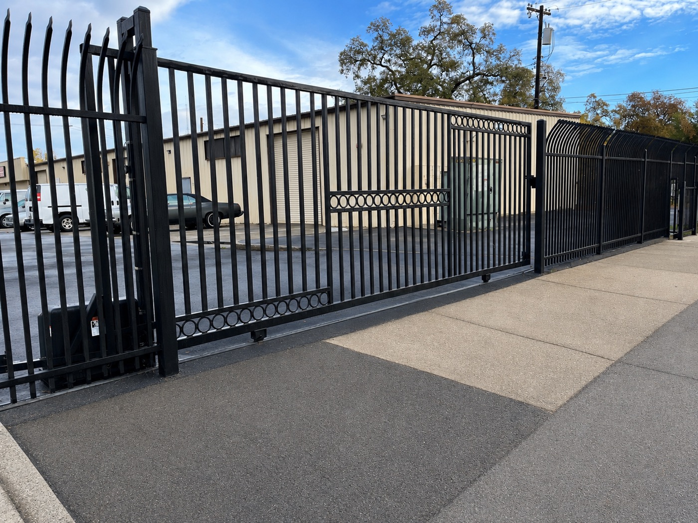Black steel security sliding gate with circle motif at a commercial property