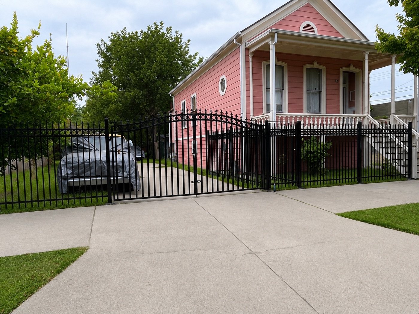 Custom iron driveway gate and matching perimeter fence with spear and circle detailing